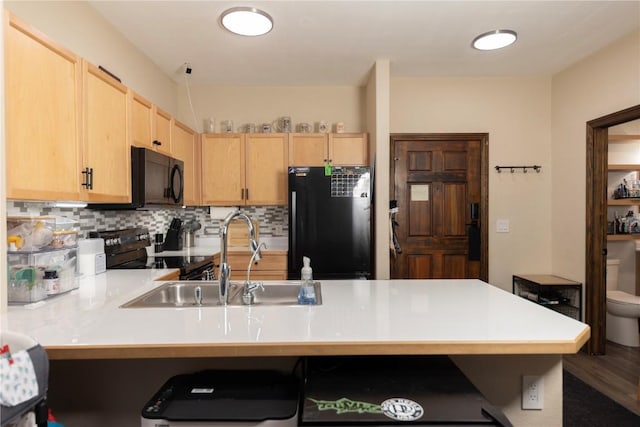 22714 US Highway 6 Unit 5958, Keystone, CO 80435 - kitchen featuring black appliances, a peninsula, a sink, light brown cabinets, and decorative backsplash