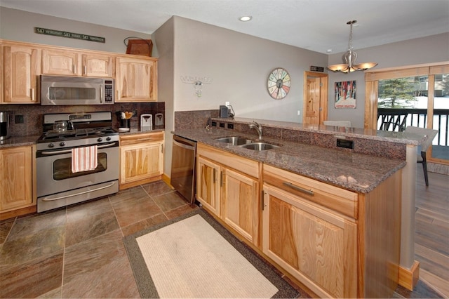 164 Buck Ridge Rd Unit 164, Summit Cove, CO 80435 - kitchen with appliances with stainless steel finishes, a peninsula, light brown cabinets, decorative backsplash, and dark stone counters