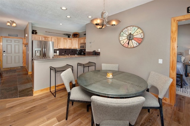 164 Buck Ridge Rd Unit 164, Summit Cove, CO 80435 - dining area with recessed lighting, a chandelier, light wood-style floors, and a textured ceiling