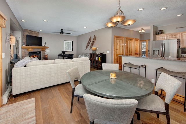 164 Buck Ridge Rd Unit 164, Summit Cove, CO 80435 - dining room featuring a fireplace, recessed lighting, a ceiling fan, and light wood-style flooring