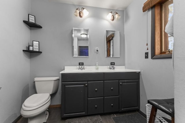 21490 2nd Ave, Milner, CO 80487 - bathroom featuring toilet, baseboards, double vanity, and wood finished floors