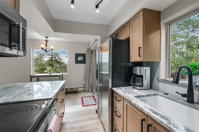 6941 Ryan Gulch Rd Unit 6941, Silverthorne, CO 80498 - kitchen with stainless steel microwave, range with electric cooktop, light stone counters, brown cabinets, and light wood-style floors
