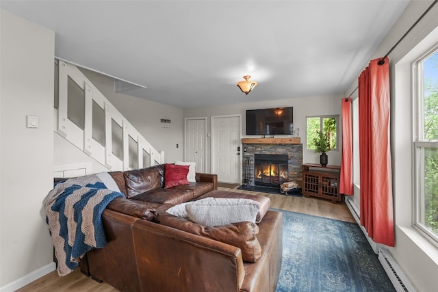 6941 Ryan Gulch Rd Unit 6941, Silverthorne, CO 80498 - living area with baseboard heating, wood finished floors, plenty of natural light, and a fireplace
