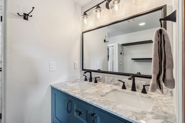 full bath featuring double vanity, visible vents, and a sink