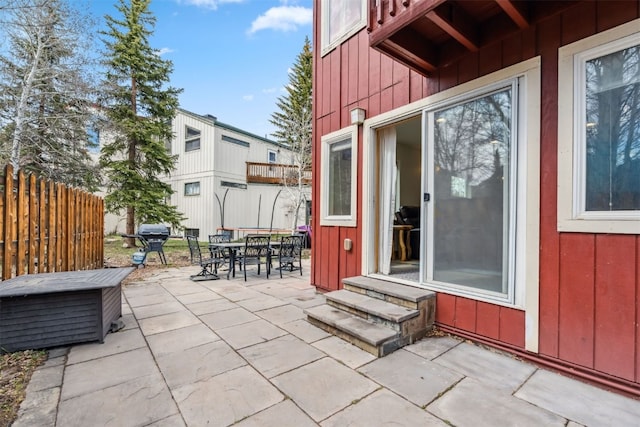 view of patio / terrace with a grill, entry steps, fence, and outdoor dining space