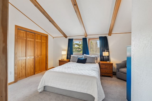 bedroom with lofted ceiling with beams, light carpet, and a closet