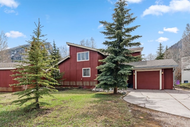 view of front of property with a mountain view, concrete driveway, and a front yard