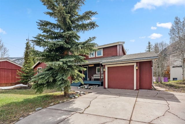view of front facade featuring concrete driveway, an attached garage, and covered porch