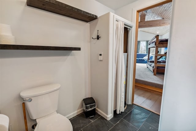 bathroom with toilet and baseboards