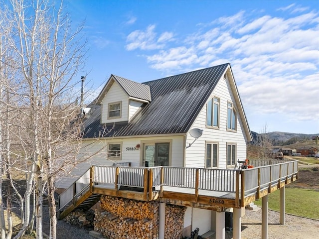 57680 Saturn Ct, Clark, CO 80428 - view of front of home with a deck, an attached garage, and metal roof