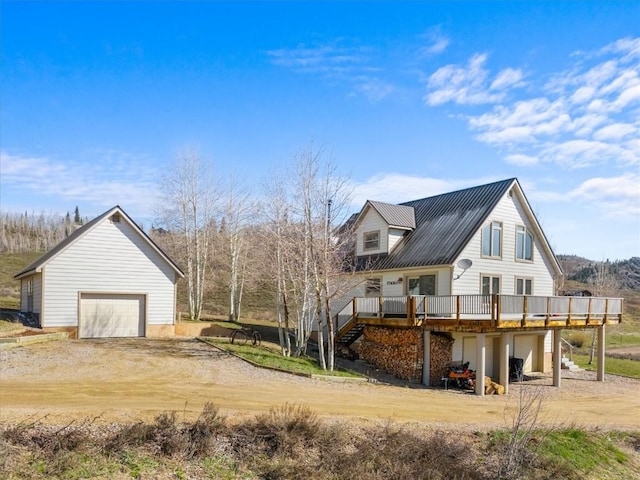 57680 Saturn Ct, Clark, CO 80428 - view of side of property featuring a wooden deck, a garage, dirt driveway, and metal roof