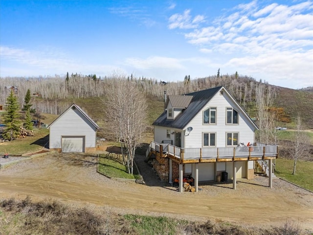 57680 Saturn Ct, Clark, CO 80428 - rear view of property featuring a deck with mountain view, dirt driveway, a detached garage, and an outdoor structure