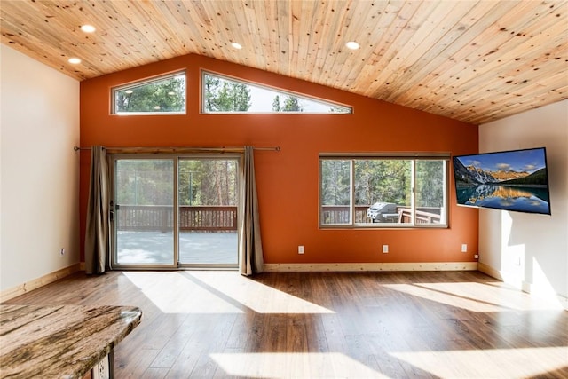 unfurnished living room featuring wood-type flooring, vaulted ceiling, and plenty of natural light