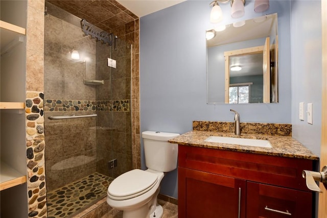 bathroom featuring a shower stall, toilet, and vanity
