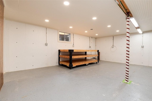 finished basement featuring a workshop area and recessed lighting