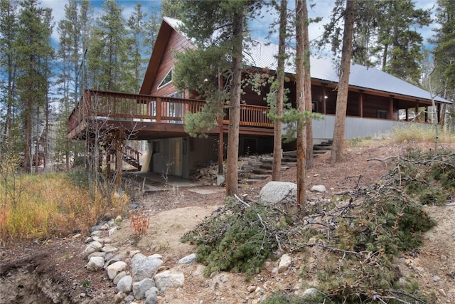 rear view of property with stairs and a deck