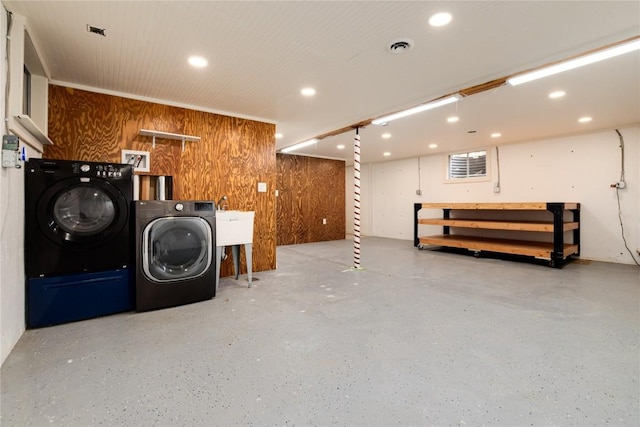 finished below grade area featuring recessed lighting, independent washer and dryer, visible vents, and wooden walls