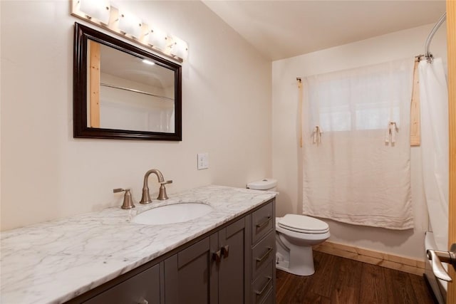 full bath featuring baseboards, shower / bath combo with shower curtain, toilet, wood finished floors, and vanity