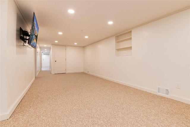 finished below grade area with baseboards, visible vents, recessed lighting, and light colored carpet