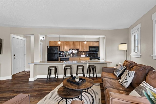 living area featuring a textured ceiling, dark wood-style floors, and baseboards