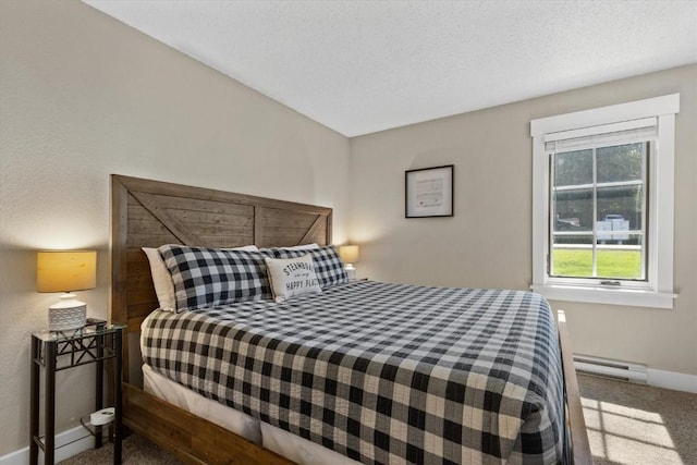 bedroom featuring baseboards, a baseboard heating unit, and carpet floors