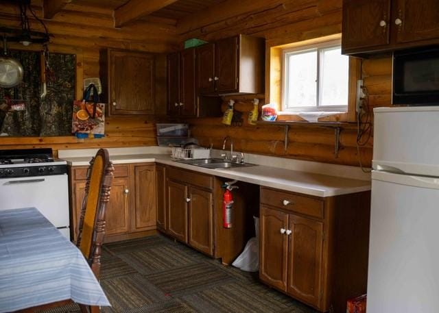 80 Sapling Ln, Craig, CO 81625 - kitchen with white appliances, light countertops, beam ceiling, and log walls