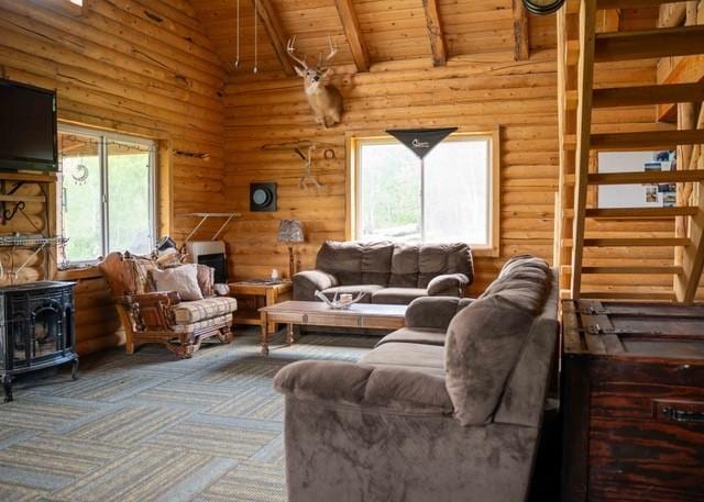 80 Sapling Ln, Craig, CO 81625 - living room featuring a wood stove, a wooden ceiling with exposed beams, carpet floors, high vaulted ceiling, and log walls