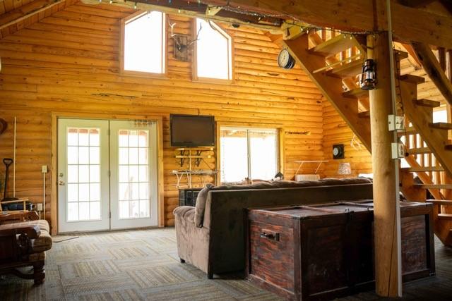 80 Sapling Ln, Craig, CO 81625 - living room with rustic walls, stairs, high vaulted ceiling, and carpet floors