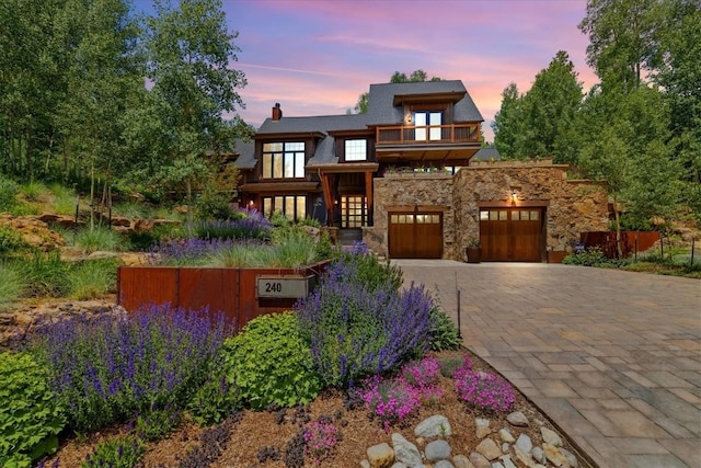 240 Two Cabins Dr, Silverthorne, CO 80498 - view of front facade featuring a balcony, stone siding, decorative driveway, and a chimney