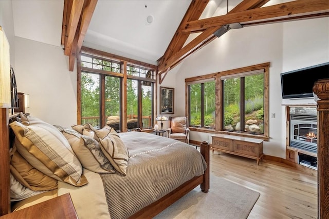240 Two Cabins Dr, Silverthorne, CO 80498 - bedroom featuring beam ceiling, high vaulted ceiling, light wood-type flooring, and a glass covered fireplace