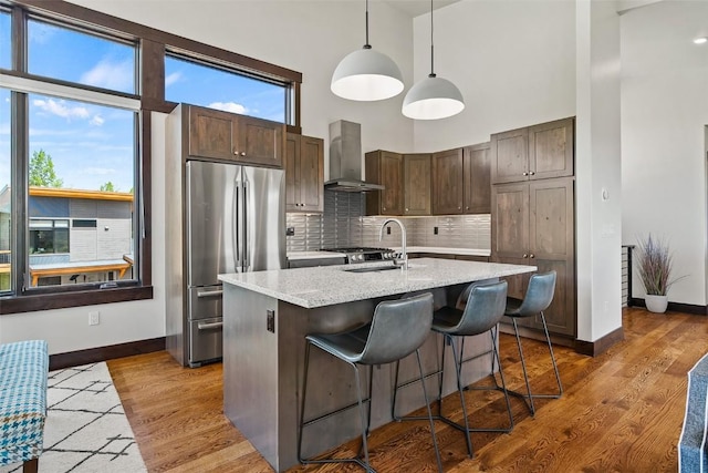 18 Lena Way, Silverthorne, CO 80498 - kitchen featuring wall chimney exhaust hood, freestanding refrigerator, baseboards, a high ceiling, and dark brown cabinets