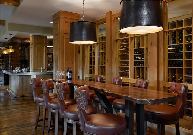 wine area with indoor wet bar and wood finished floors