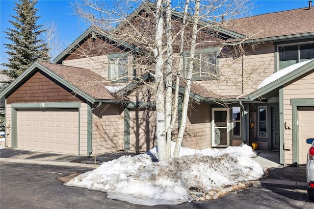 view of front of home featuring an attached garage and roof with shingles