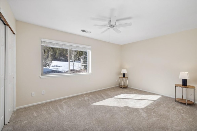 unfurnished bedroom featuring baseboards, visible vents, a closet, ceiling fan, and carpet floors