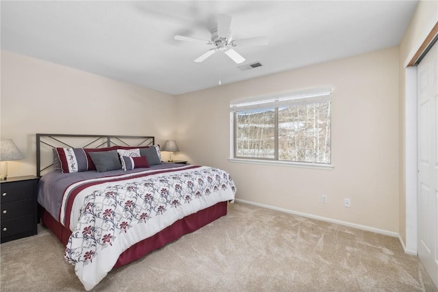 carpeted bedroom featuring baseboards, a ceiling fan, visible vents, and a closet