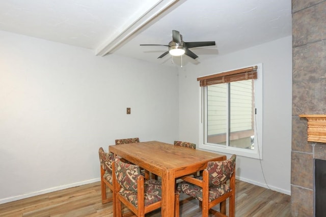 805 Columbine Rd Unit 105, Breckenridge, CO 80424 - dining space featuring a fireplace, beam ceiling, light wood finished floors, and baseboards