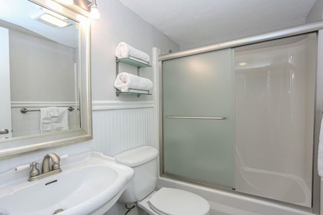 805 Columbine Rd Unit 105, Breckenridge, CO 80424 - full bath featuring toilet, a wainscoted wall, a sink, and combined bath / shower with glass door