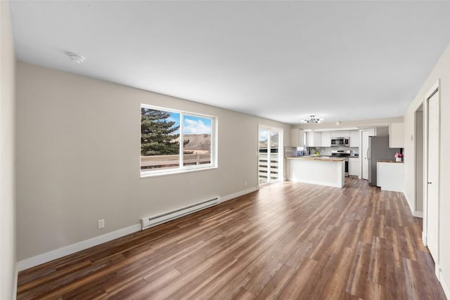 321 18th St, Kremmling, CO 80459 - unfurnished living room with a baseboard radiator and dark wood-style floors
