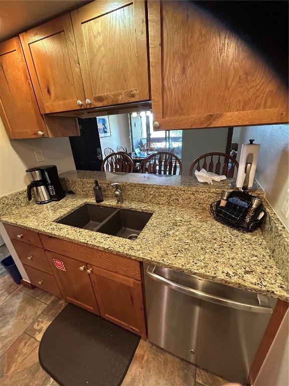 317 La Bonte St Unit 107, Dillon, CO 80435 - kitchen with dishwasher, brown cabinetry, and light stone counters