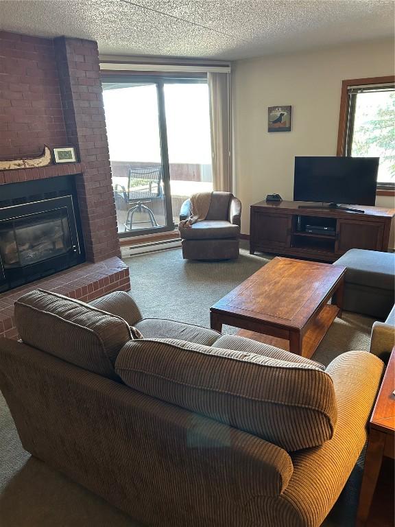 317 La Bonte St Unit 107, Dillon, CO 80435 - living area featuring carpet, healthy amount of natural light, and a brick fireplace