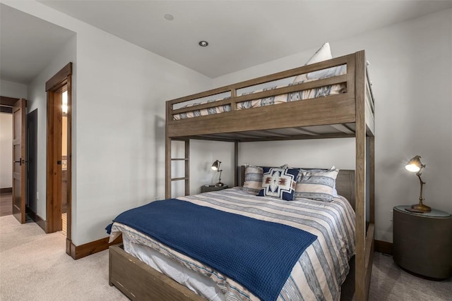 bedroom featuring light carpet and baseboards