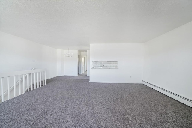 spare room with a baseboard heating unit, a textured ceiling, baseboards, an inviting chandelier, and carpet