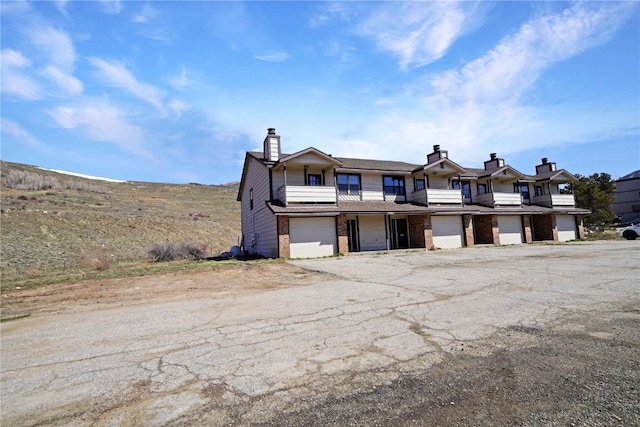 245 Straight Creek Dr Unit A, B, C, D, Dillon, CO 80435 - multi unit property featuring an attached garage, brick siding, a chimney, and driveway