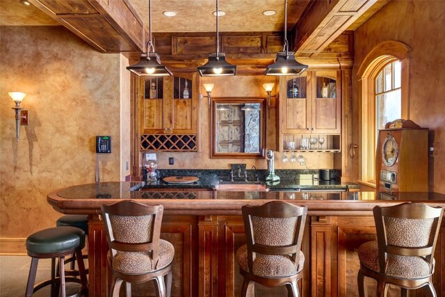 33800 Catamount Dr, Steamboat Springs, CO 80487 - indoor wet bar featuring beamed ceiling, pendant lighting, and a textured wall