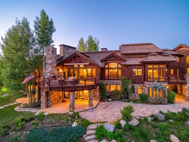 33800 Catamount Dr, Steamboat Springs, CO 80487 - back of property with a patio area, stone siding, a chimney, and a deck