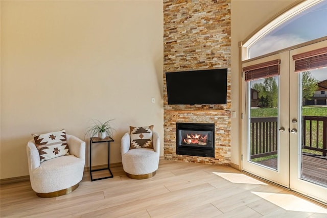 620 Parkview Dr Unit 61, Steamboat Springs, CO 80487 - sitting room featuring french doors, wood finished floors, a stone fireplace, and baseboards