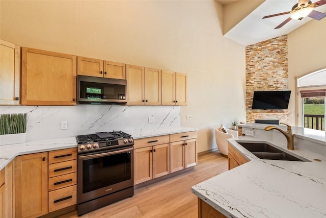 620 Parkview Dr Unit 61, Steamboat Springs, CO 80487 - kitchen with stainless steel appliances, a sink, high vaulted ceiling, open floor plan, and light wood-type flooring