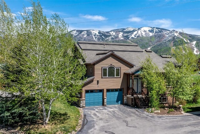 620 Parkview Dr Unit 61, Steamboat Springs, CO 80487 - split level home featuring an attached garage, asphalt driveway, a mountain view, stone siding, and roof with shingles