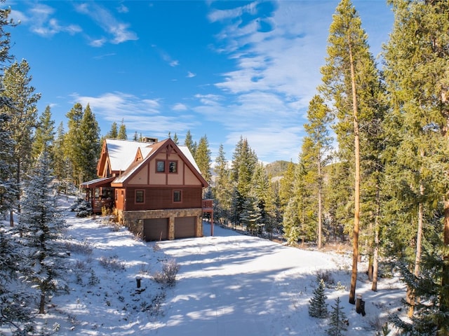 66 Chaparral Ln, Breckenridge, CO 80424 - view of snow covered exterior featuring stone siding, a garage, and a view of trees