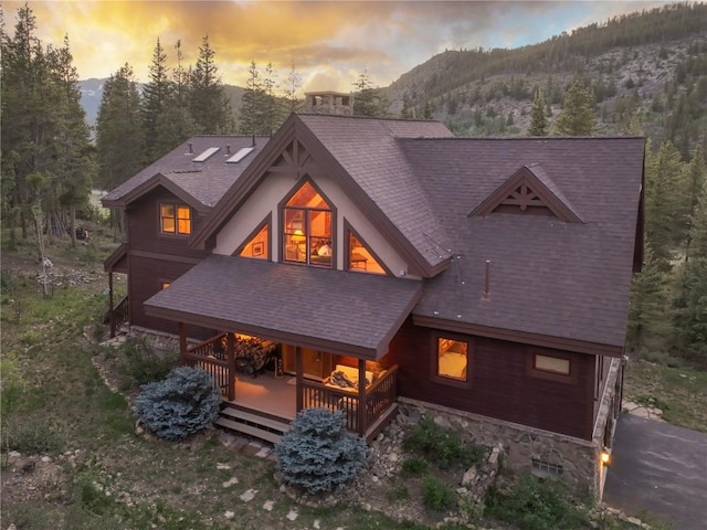 66 Chaparral Ln, Breckenridge, CO 80424 - rear view of house with a mountain view, covered porch, stone siding, and a shingled roof